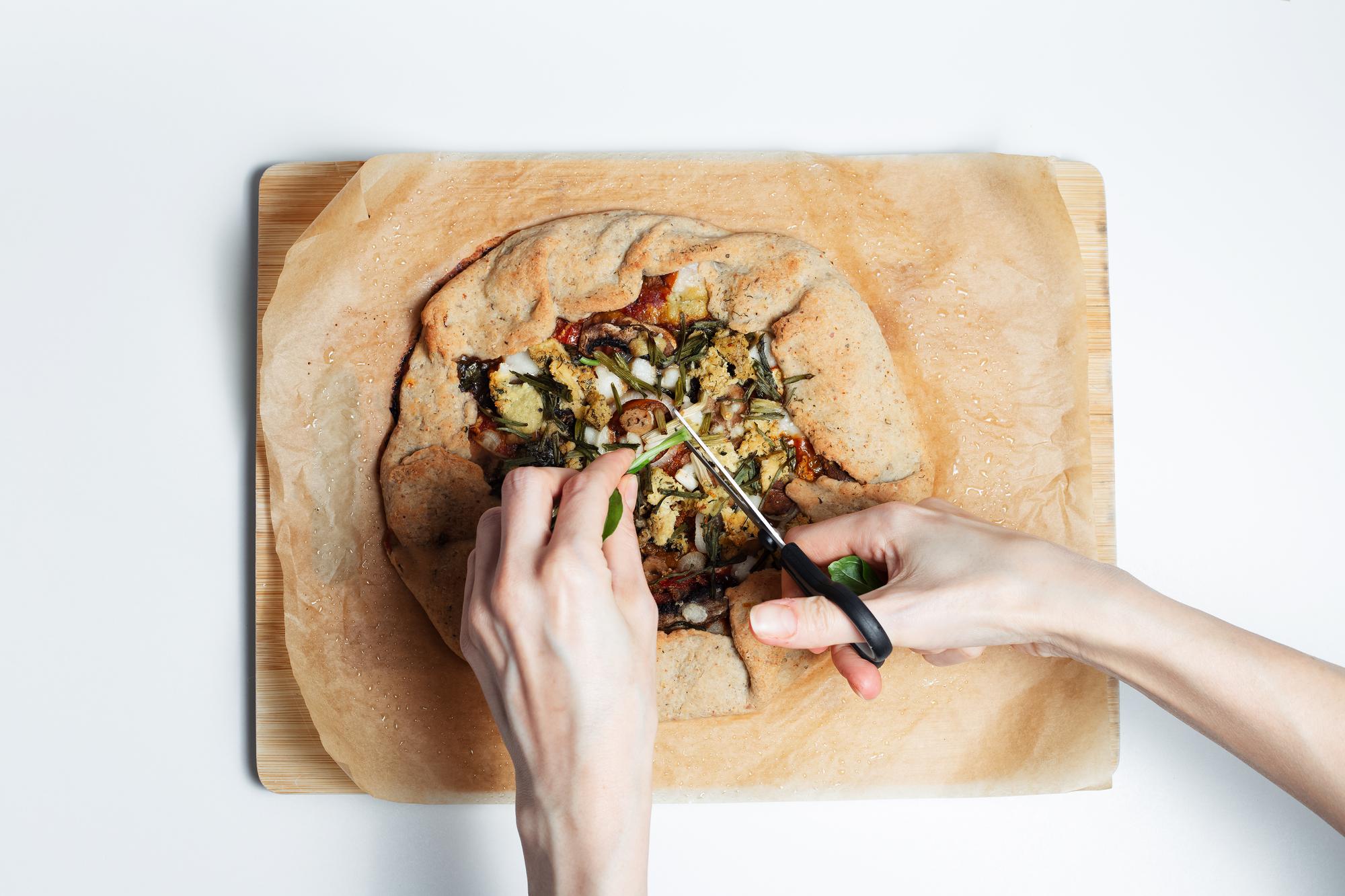 Hands preparing rustic seasonal dish on wooden board